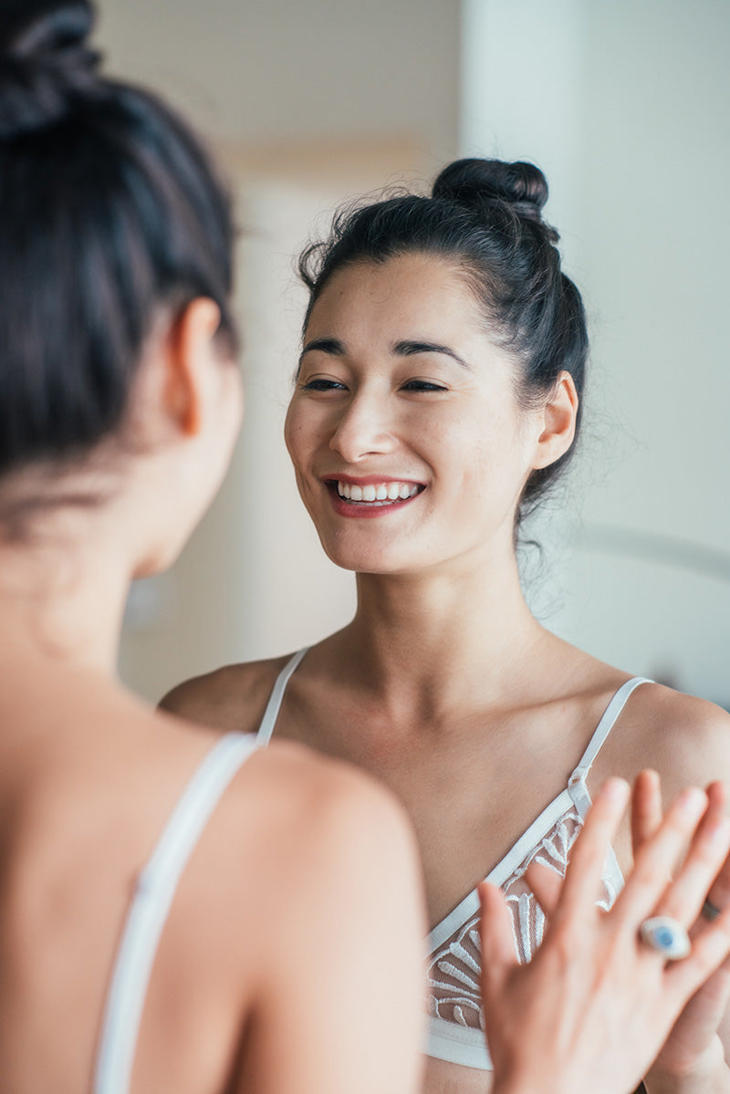 woman smiling at mirror