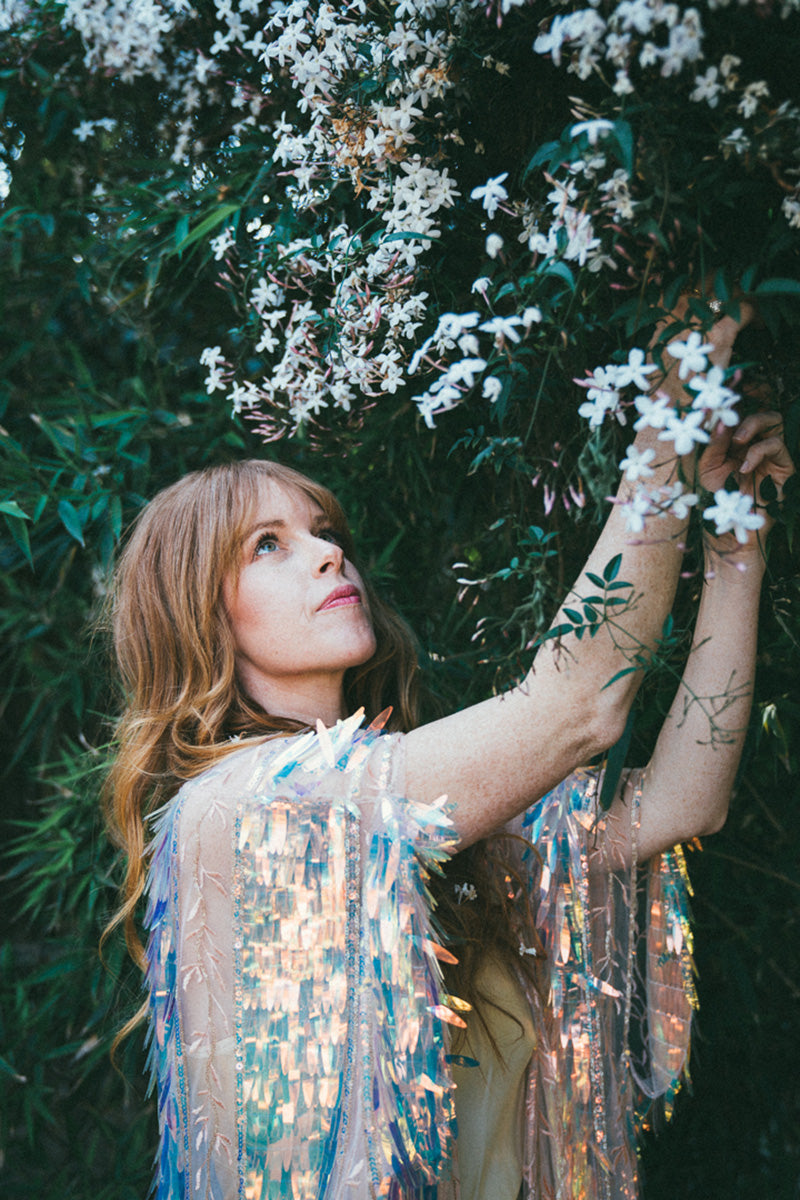 woman picking flowers from tree