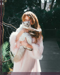 woman in pink holding cat
