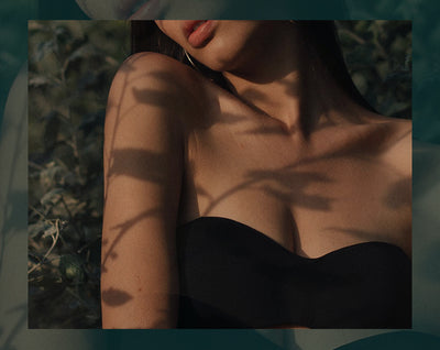 woman in sensual clothing in front of leaves